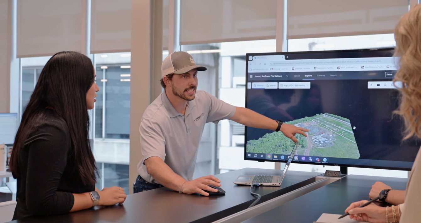 Two McCownGordon associates looking at a screen and pointing to a topography report