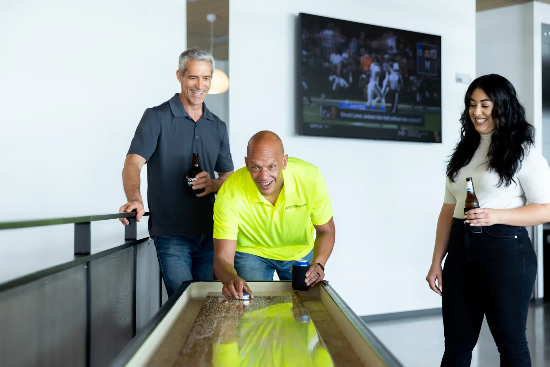 Three McCownGordon Construction associates enhancing their culture by playing shuffle board together