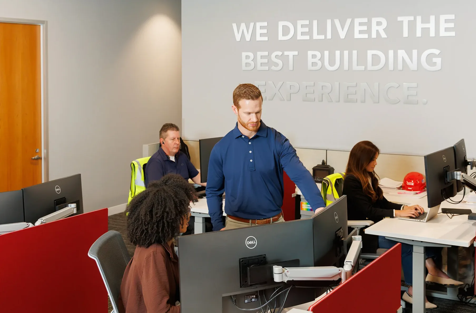 McCownGordon associates working at their desks while one man talks to a woman and points at her computer