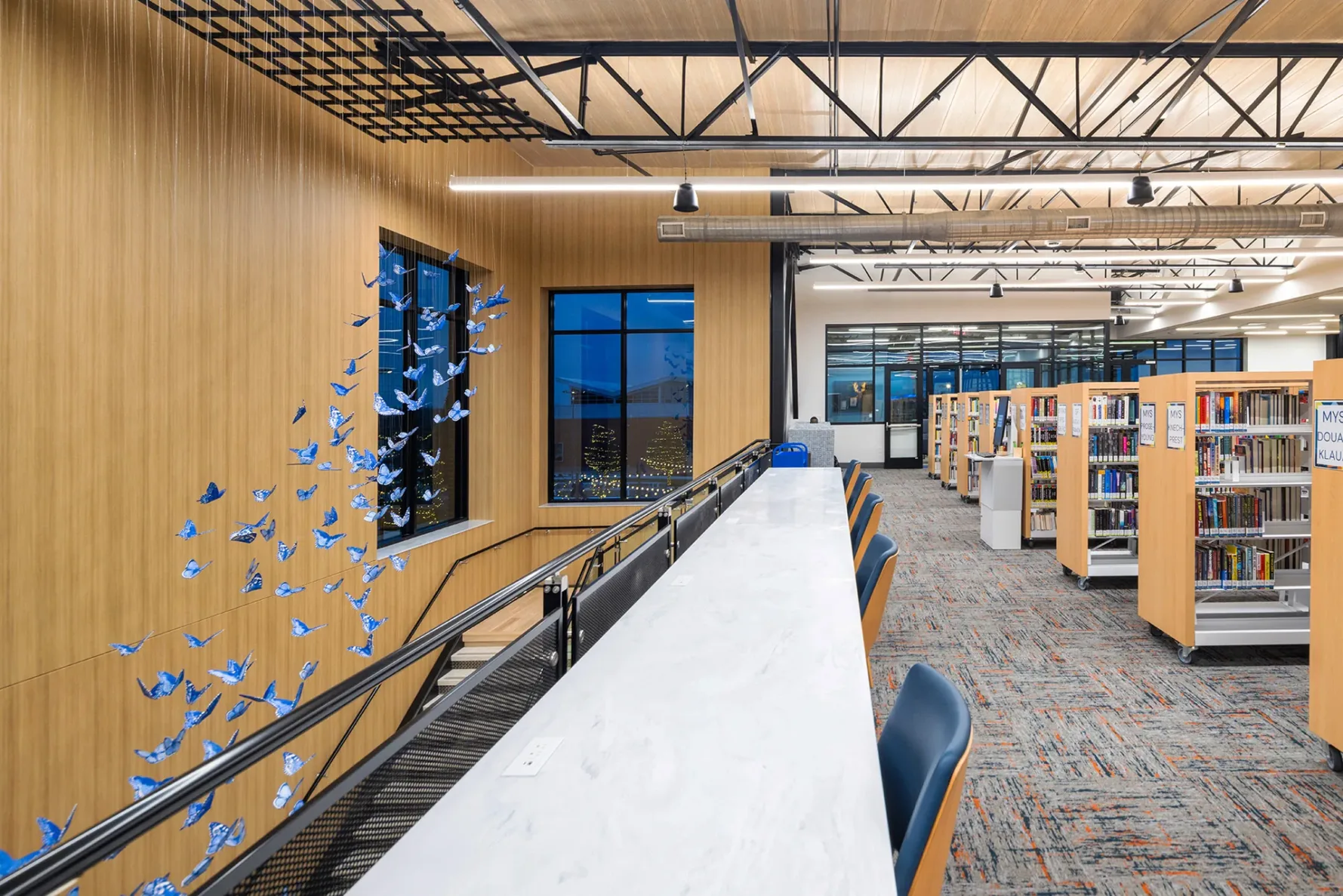 Staircase that leads up to shelves of books at the City of Anna Texas Library, built by McCownGordon